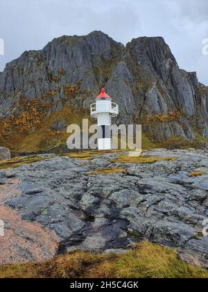 Colpo verticale di un faro sulla collina rocciosa Foto Stock