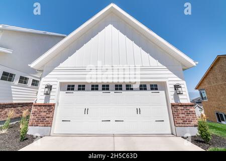 Esterno di un garage con legno bianco e mattoni rossi laterali Foto Stock