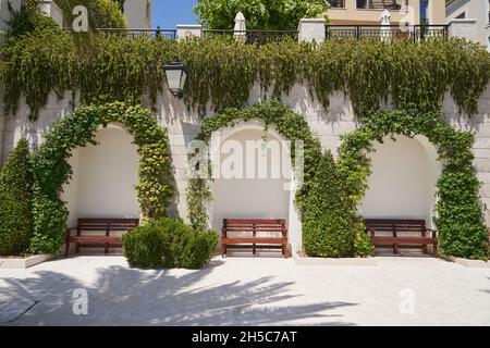 Archi nella parete di un edificio decorato con piante rampicanti in europa. Foto Stock