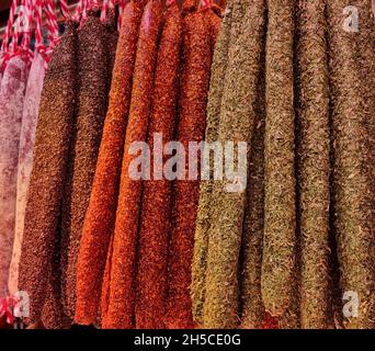 Vista di diversi prodotti a base di carne appesi ad una bancarella di carne in un mercato di Barcellona Foto Stock