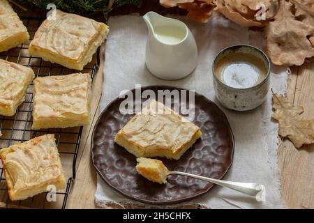 Fette di torta di mele con meringa servita con caffè. Stile rustico. Foto Stock