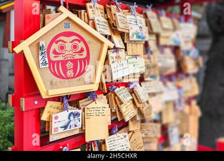 tokyo, giappone - settembre 17 2019: Grande placca di Ema di legno Shinto adornata con il bodhidharma buddista o divinità daruma con le parole desiderose per succhia Foto Stock