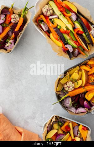 Verdure fresche tritate cucinate al forno in vari piatti di ceramica, vista dall'alto Foto Stock
