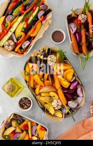 Verdure fresche tritate cucinate al forno in vari piatti di ceramica, vista dall'alto Foto Stock