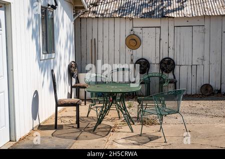 Foto di un patio all'aperto con cappello e mobili da esterno in una fattoria nella Valle Centrale della California. Foto Stock