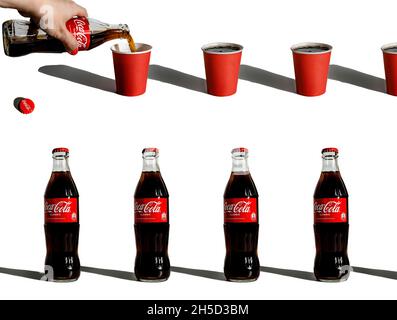 Composizione creativa con bottiglie ripetute di coca-cola e bicchieri di carta Foto Stock