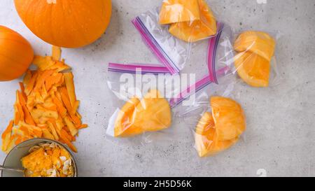 Fette fresche di zucca sbucciata sbucciata in sacchetti con chiusura a zip, pronte per essere congelate, disposte in piano Foto Stock