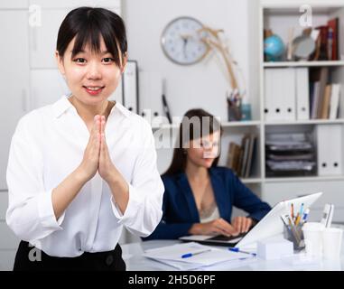 Il direttore asiatico accoglie gli ospiti in ufficio Foto Stock