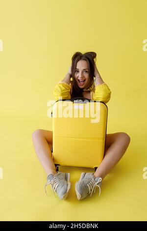 Donna gioiosa con borsa carrello in posa in studio Foto Stock