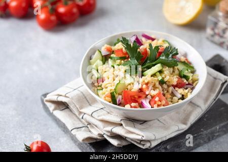 Bulgur orientale e insalata di verdure tovouleh in un piatto. Piatto vegetariano. Foto Stock