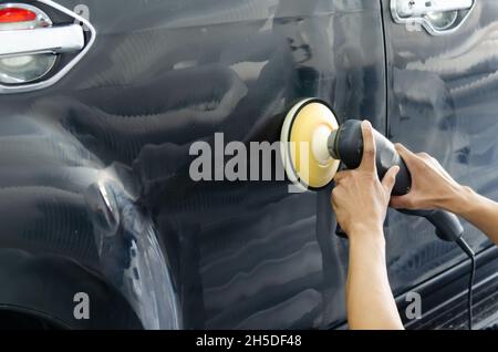 Uomo mano che tiene una macchina lucidatrice dell'automobile. Dettagli auto lucidatura e cera. Foto Stock