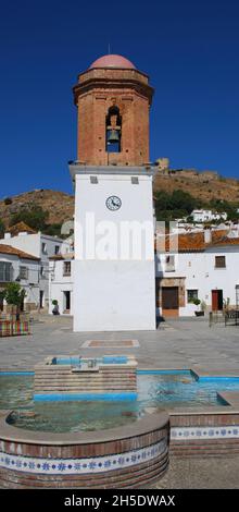 Campanile e fontana nella piazza della città con il castello sul retro, Jimena de la Frontera, Provincia di Cadice, Andalusia, Spagna, Europa occidentale. Foto Stock