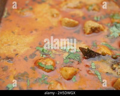 KOLKATA, INDIA - 18 settembre 2021: Kashmiri Dum Alo patate in salsa rossa su sfondo bianco. Guarnito con coriandolo servire caldo con riso o Naan Foto Stock