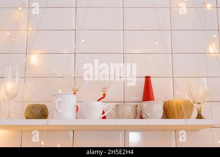 Interni con cucina luminosa, decorazioni rosse e decorazioni con alberi di Natale. Cucinare una cena di festa a casa Foto Stock