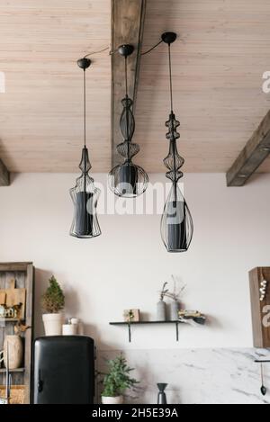 Moderne lampade nere sul soffitto all'interno di una casa di campagna in legno Foto Stock