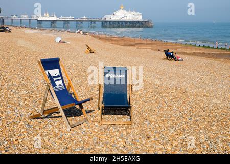 Sdraio sulla spiaggia di ciottoli di Eastbourne di fronte al Victorian Eastbourne Pier, aperto nel 1872 a Eastbourne East Sussex England UK Foto Stock