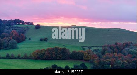 Splendido paesaggio di alba che si affaccia sul villaggio di Oare dal bordo sud del Marlborough Downs, adiacente a Pewsey vale, Wiltshire AON Foto Stock