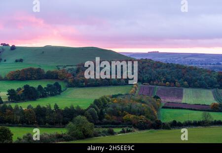 Splendido paesaggio di alba che si affaccia sul villaggio di Oare dal bordo sud del Marlborough Downs, adiacente a Pewsey vale, Wiltshire AON Foto Stock