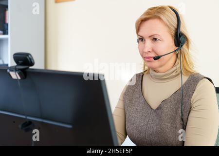 Un bel dipendente del call center ascolta attentamente. Business o lavoro da casa concetto. Foto Stock