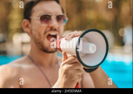 Bagnino maschio che avverte i visitatori della situazione di emergenza Foto Stock