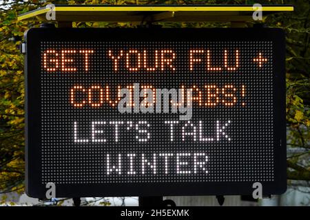 Bridport, Dorset, Regno Unito. 9 novembre 2021. Segno elettronico accanto alla A35 a Bridport in Dorset esortando la gente ad ottenere la loro influenza e covid jab prima dell'inverno. Picture Credit: Graham Hunt/Alamy Live News Foto Stock