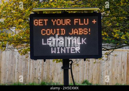 Bridport, Dorset, Regno Unito. 9 novembre 2021. Segno elettronico accanto alla A35 a Bridport in Dorset esortando la gente ad ottenere la loro influenza e covid jab prima dell'inverno. Picture Credit: Graham Hunt/Alamy Live News Foto Stock