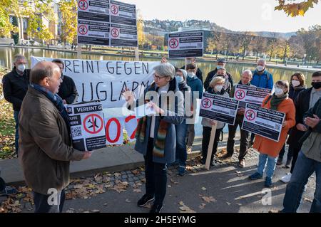 Stoccarda, Germania. 9 novembre 2021. I rappresentanti delle iniziative dei cittadini contro il rumore degli aerei si dimostrano nello Schlossgarten di fronte al parlamento di Stato con bandiere contro il rumore degli aerei che si creerebbe nelle loro comunità da un cambiamento del percorso di decollo e atterraggio. A sinistra c'è il portavoce delle iniziative dei cittadini, Rolf Keck, che consegna una scatola di firme al commissario per la protezione del rumore dello Stato, Elke Zimmer (M). Oltre 15,000 persone hanno firmato una petizione contro il cambiamento del percorso di volo. Credit: Bernd Weißbrod/dpa/Alamy Live News Foto Stock