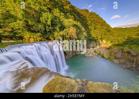 Lunga esposizione della cascata nell'attrazione turistica Shifen durante il tramonto, New Taipei City, Taiwan. Foto Stock