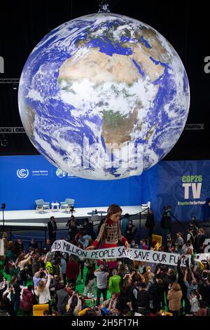 Glasgow, Scozia, Regno Unito. 9 Nov 2021. NELLA FOTO: Giant Puppet ‘Little Amal’ prende il centro della scena nella OVO Arena alla COP26 Climate Change Conference con un banner sottostante che rivela le parole “1.8 MILIONI DI PERSONE DICONO: CSAVE OUT FUTURE NOW” Credit: Colin Fisher/Alamy Live News Foto Stock