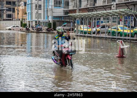 Samut Prakarn, Tailandia. 9 novembre 2021. Un motociclista corre lungo la strada allagata durante un'alluvione lampo al mercato fresco Pak Nam a Samut Prakan.le alluvioni lampo si sono verificate in molte aree basse a fianco del fiume Chao Praya a Bangkok e nelle province vicine come Samut Prakan a Nonthaburi a causa di forti piogge. Credit: SOPA Images Limited/Alamy Live News Foto Stock