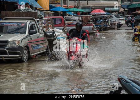 Samut Prakarn, Tailandia. 9 novembre 2021. Un motociclista corre lungo la strada allagata durante un'alluvione lampo al mercato fresco Pak Nam a Samut Prakan.le alluvioni lampo si sono verificate in molte aree basse a fianco del fiume Chao Praya a Bangkok e nelle province vicine come Samut Prakan a Nonthaburi a causa di forti piogge. Credit: SOPA Images Limited/Alamy Live News Foto Stock