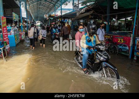 Samut Prakarn, Tailandia. 9 novembre 2021. Un motociclista corre lungo la strada allagata durante un'alluvione lampo al mercato fresco Pak Nam a Samut Prakan.le alluvioni lampo si sono verificate in molte aree basse a fianco del fiume Chao Praya a Bangkok e nelle province vicine come Samut Prakan a Nonthaburi a causa di forti piogge. Credit: SOPA Images Limited/Alamy Live News Foto Stock