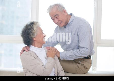 Vecchio che dà i fiori della moglie Foto Stock