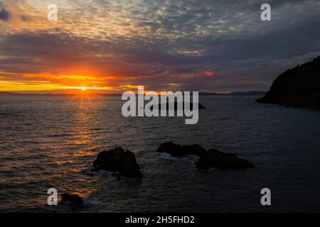 WA19749-00...WASHINGTON - Tramonto sulle Isole San Juan e sullo stretto di Roserio da Roserio Head nel Deception Pass state Park. Foto Stock