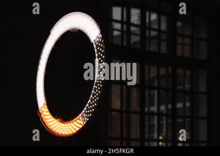 Luce a LED circolare che si illumina in uno studio fotografico scuro, foto ravvicinate con messa a fuoco selettiva Foto Stock