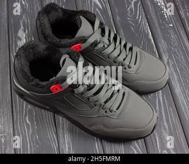 Sneaker grigie su sfondo grigio in legno. Vista dall'alto delle scarpe sportive Foto Stock