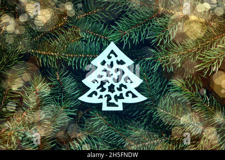 Un concetto di Natale fatto di rami di abete con un osso bianco di legno nel centro. Vista dall'alto. Foto Stock