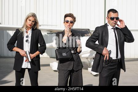 Guardia del corpo celebrità e VIP persona di sicurezza vicino servizi di protezione. Agente di polizia professionale forze speciali con occhiali da sole in tuta civile nera Foto Stock