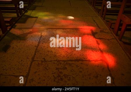 La luce del sole si riflette attraverso vetrate colorate all'interno della chiesa di Saint Jacques a Montauban, Francia sud-occidentale. Foto Stock