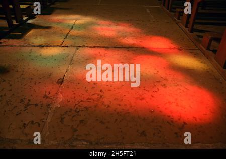 La luce del sole si riflette attraverso vetrate colorate all'interno della chiesa di Saint Jacques a Montauban, Francia sud-occidentale. Foto Stock