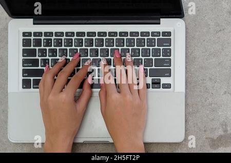 Vista dall'alto mano donna che utilizza una tastiera per computer laptop. Tecnologia aziendale. Flat lay Foto Stock