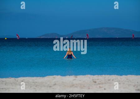 Una donna bionda nuota nel mar Egeo su Ilica Plaji nella provincia di Alaçatı Izmir, Turchia. Foto Stock