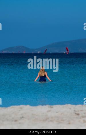Una donna bionda nuota nel mar Egeo su Ilica Plaji nella provincia di Alaçatı Izmir, Turchia. Foto Stock