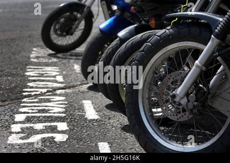 Ruote anteriori di motociclette parcheggiate in una baia Foto Stock