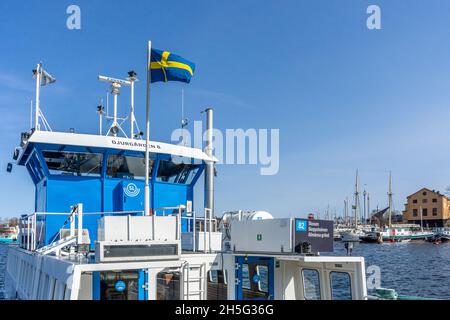 Stoccolma, Svezia - 17 aprile 2021: Bandiera svedese sui traghetti ormeggiati appartenenti alle linee regolari del traffico locale di Stoccolma Foto Stock