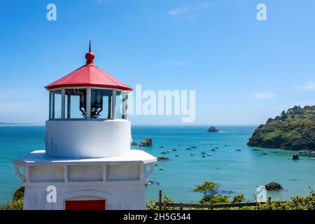 Primo piano del faro di Trinidad Head che si affaccia sulla baia di Trinidad California con le barche ancorate sotto Foto Stock