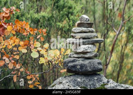Pietre di equilibrio sulla roccia nella foresta di autunno Foto Stock