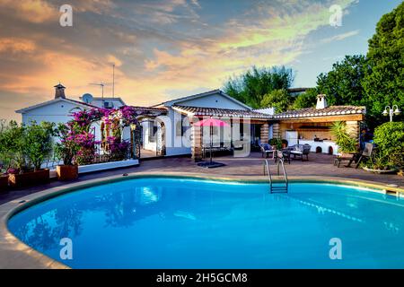 Villa mediterranea con piscina, giardino e cielo spettacolare. Foto Stock