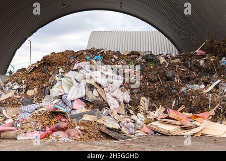 Un mucchio grande di rifiuti. C'è un grande mucchio di materie prime e vecchi materassi presso l'impianto di lavorazione dei rifiuti. Foto Stock