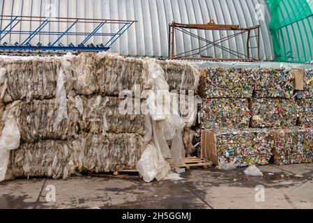 Riciclabili in balle di grandi dimensioni in una fabbrica di rifiuti. La pellicola trasparente e le lattine di alluminio sono pronte per essere spedite per la rifusione. Foto Stock